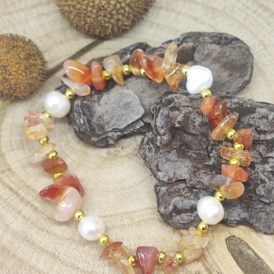 Pulseira colorida com pedras e pérolas sobre madeira