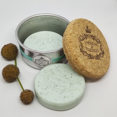 Sabonete verde claro com partículas pretas em lata metálica com tampa de cortiça e flores secas