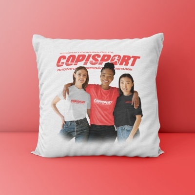 Almofada branca com imagem impressa de três pessoas e texto COPISPORT