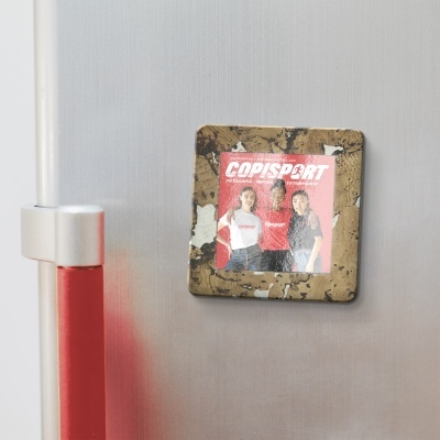Imã quadrado com moldura de cortiça e imagem com texto COPISPORT numa superfície metálica
