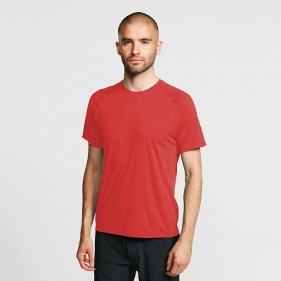 Homem com camiseta vermelha de manga curta e calças pretas em fundo cinzento