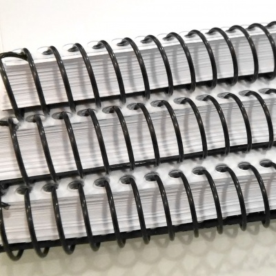 Três cadernos com espiral preto, páginas e capa brancas, empilhados