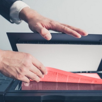 Pessoa a escanear folha vermelha em scanner preto