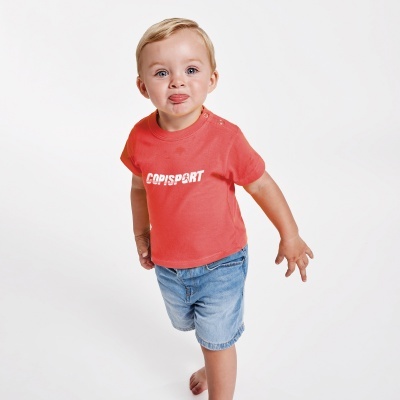 Criança com t-shirt vermelha COPISPORT e calções de ganga azuis em fundo branco