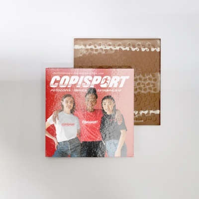 Caixa de cartão com imagem promocional da Copisport e envelope castanho