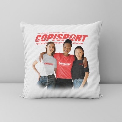Almofada branca com impressão de três pessoas vestindo t-shirts COPISPORT