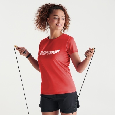 Mulher a usar t-shirt vermelha e calções pretos a saltar à corda