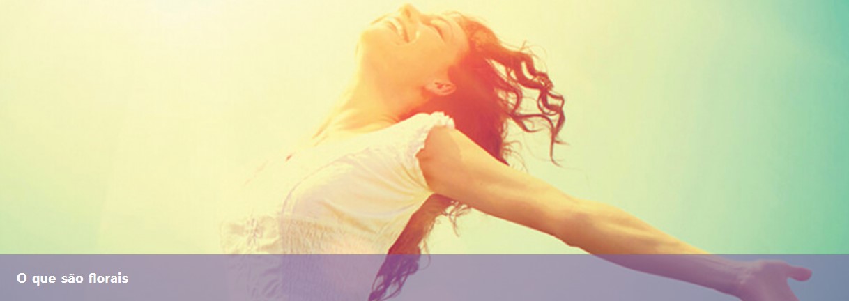 Mulher de braços abertos com camisa branca e cabelo encaracolado