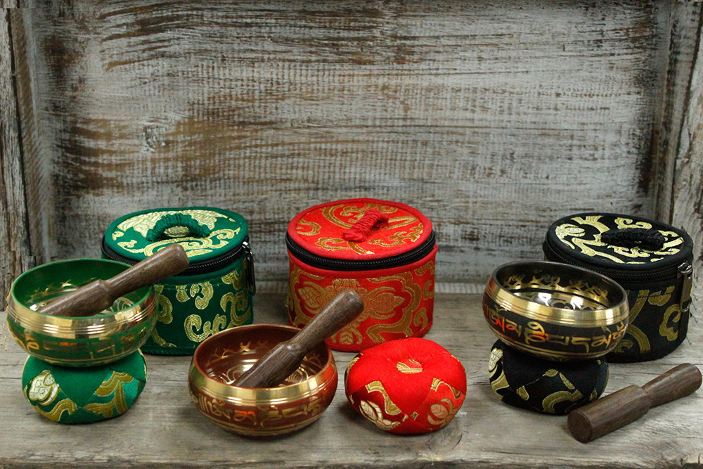 Set Mini Taças Tibetanas para presente - Vermelho Conjuntos de tigelas tibetanas douradas com almofadas e martelos em verde, vermelho e preto sobre madeira.
