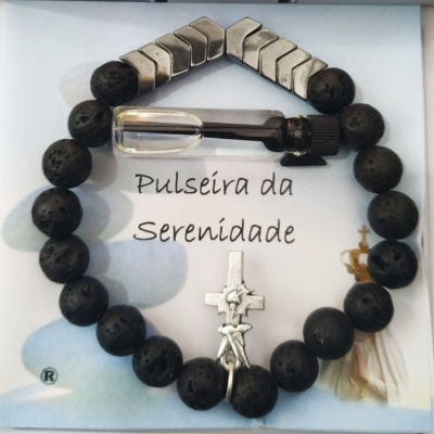 Pulseira da Serenidade com contas pretas e metálicas, pingente de cruz e ampola pequena, apresentada sobre cartão branco