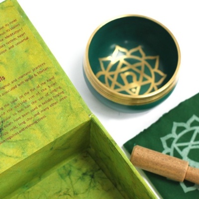 Conjunto de tigela sonora com almofada e caixa verde com texto explicativo
