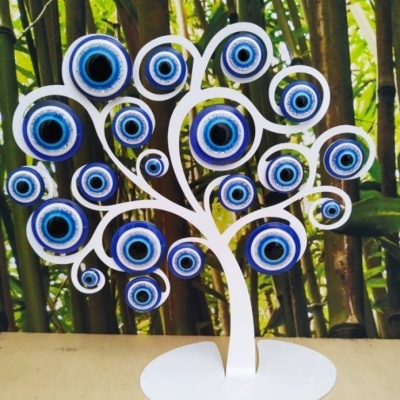 Escultura de árvore branca com olhos turcos azuis pendurados nos ramos
