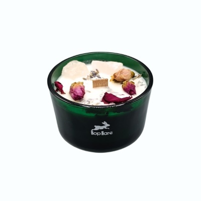 Vela aromática em frasco verde com decoração de pétalas e cristais