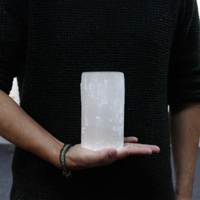 Pessoa segurando lâmpada branca translúcida cilíndrica