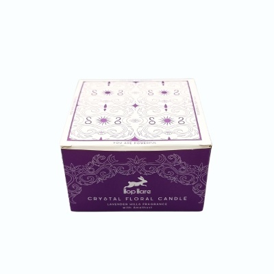 Caixa roxa e branca de vela aromática Hop Flare com texto e padrões florais