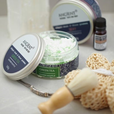 Frasco aberto de esfoliante corporal Ancient Green Tea, escova e esponja de banho