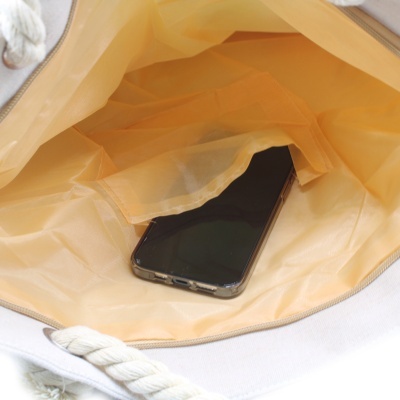Interior de bolsa amarela com telemóvel e alça de cordão branco
