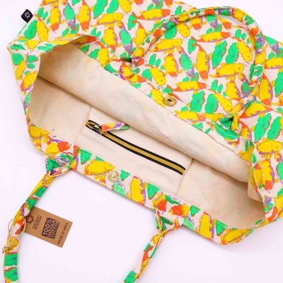 Mala de tecido colorida com padrão de pássaros e interior bege com bolso zíper