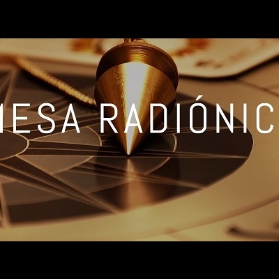 Pêndulo metálico sobre mesa radiônica com padrão geométrico e texto MESA RADIÓNICA