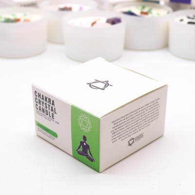 Caixa de vela Chakra Crystal Candle branca e verde com figura humana meditando e texto