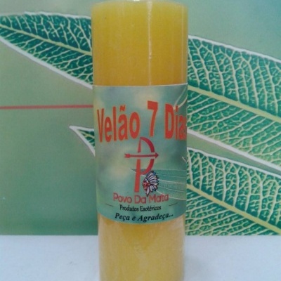 Vela amarelo claro com etiqueta colorida e texto, em fundo de folhas verdes grandes