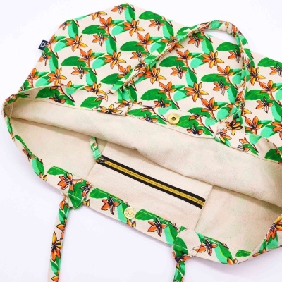 Sacola de tecido florida aberta mostrando interior creme e bolso com fecho