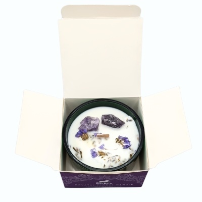 Vela branca com cristais e flores dentro de caixa roxa aberta