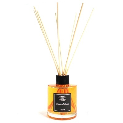 Difusor de ambiente com líquido laranja e varetas