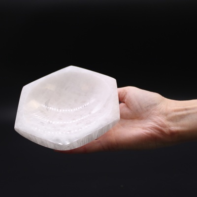 Base hexagonal de selenite branca translúcida na mão