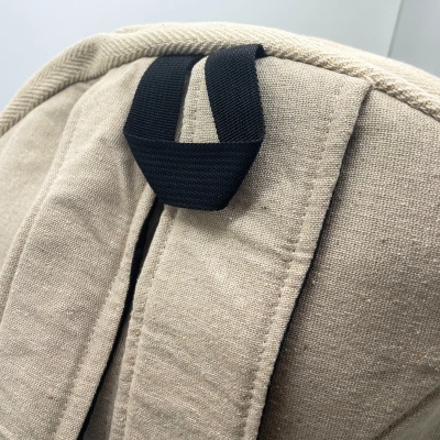 Mochila bege de tecido com alças acolchoadas e alça preta para transporte