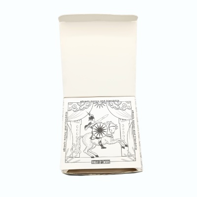 Caixa branca aberta com papel ilustrado preto e branco de cavalo e cavaleiro