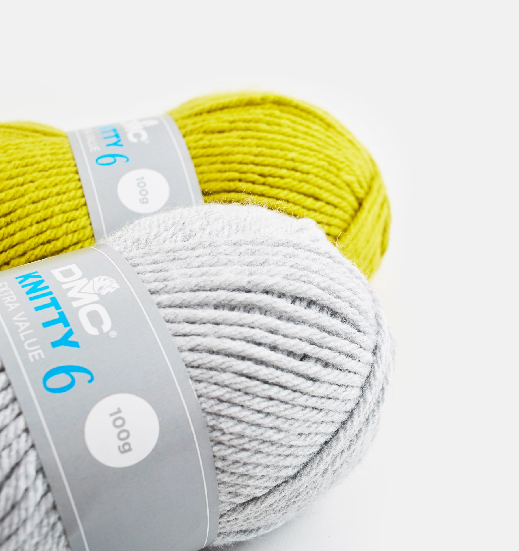 Dois novelos de lã, cinza e verde amarelo, com etiquetas cinzentas em fundo branco.