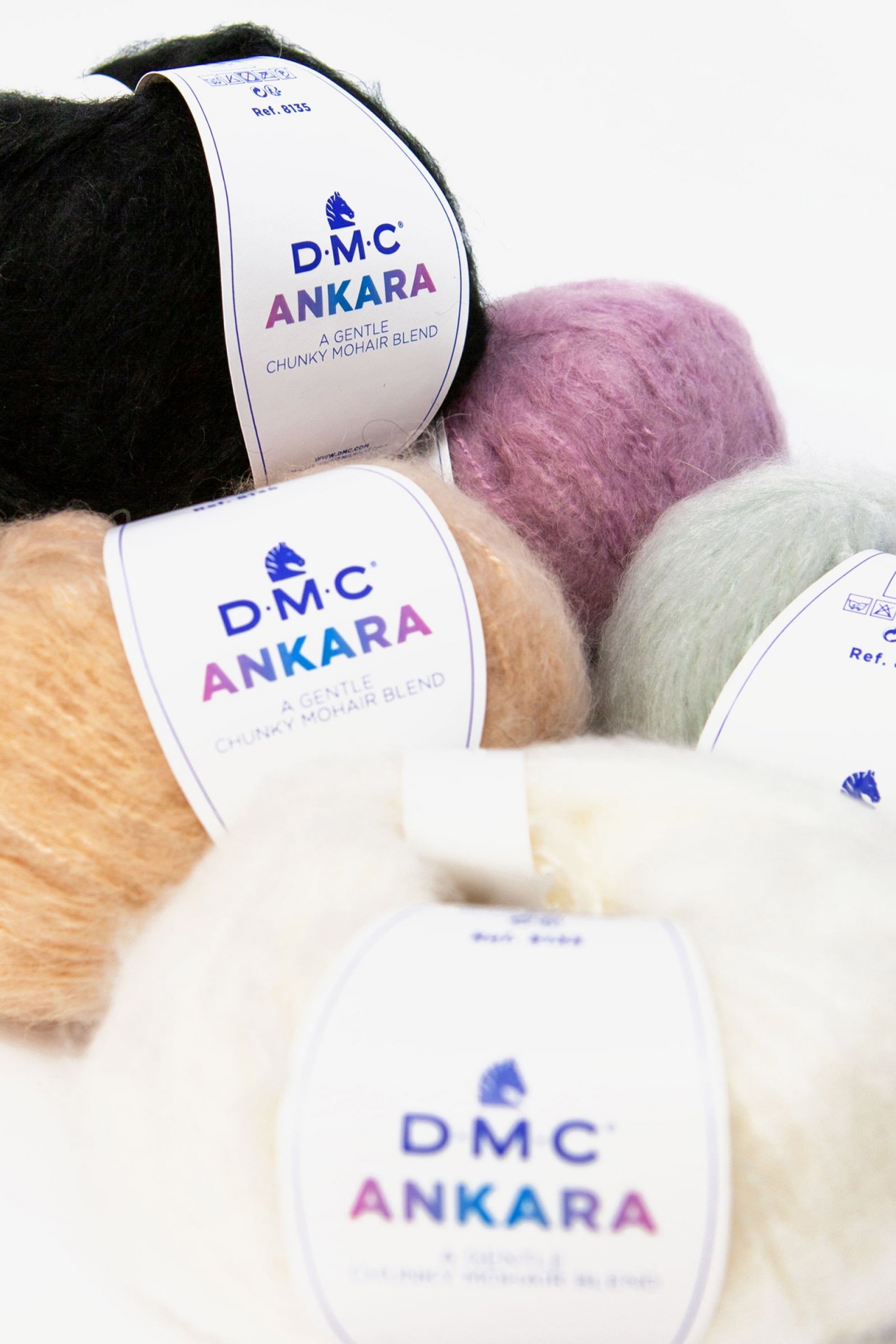 Novelos de lã DMC ANKARA em várias cores com etiquetas brancas sobre fundo branco