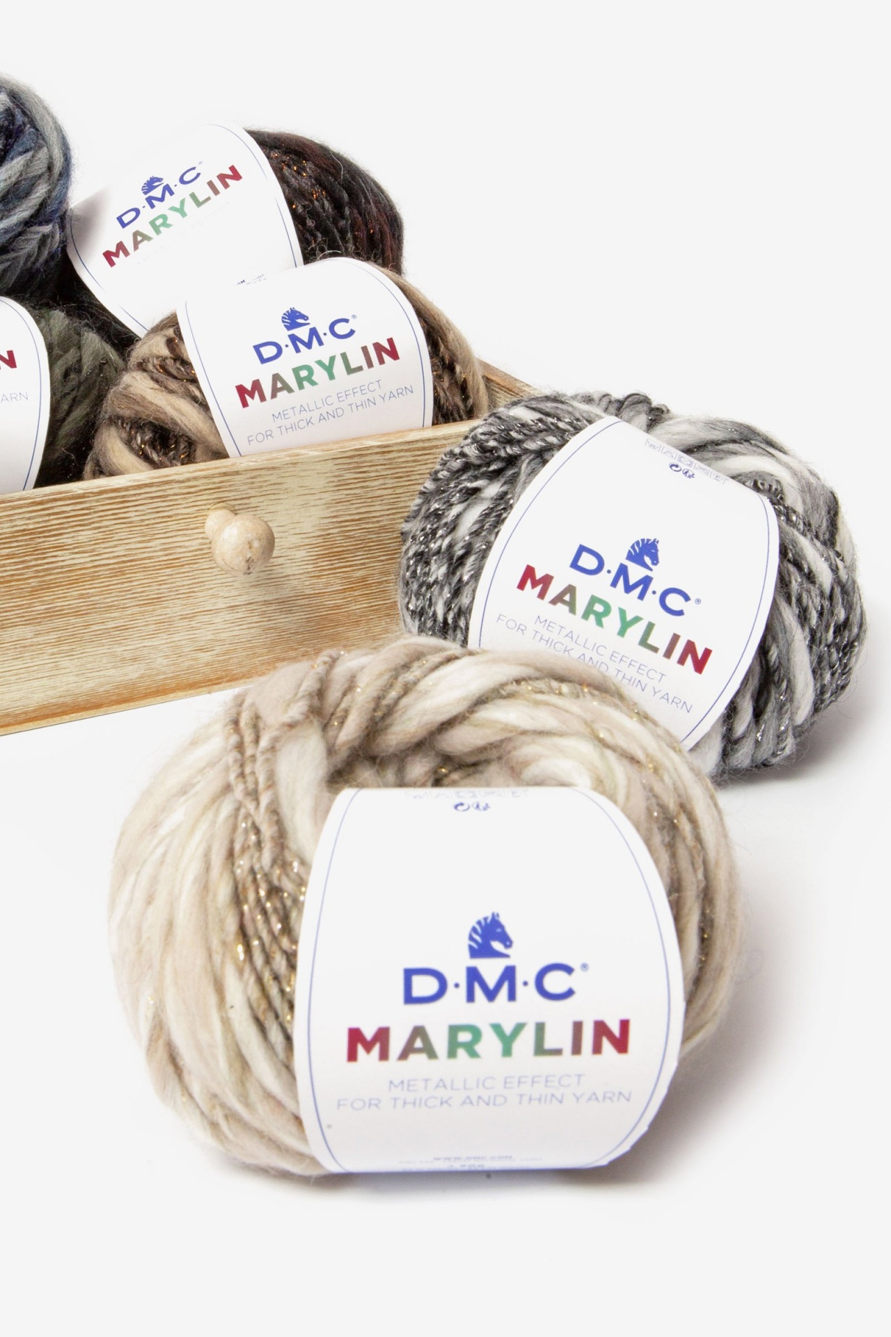 Novelos de fio de lã D.M.C. Marylin em várias cores numa caixa de madeira