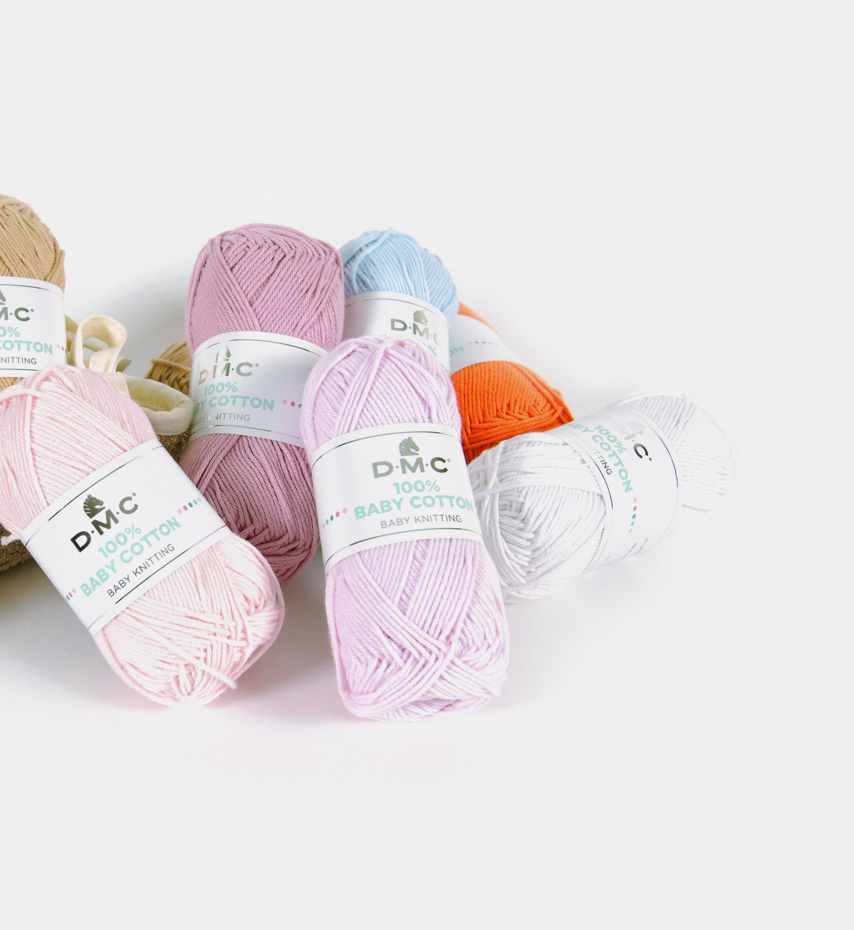 Novelos de fio DMC 100% algodão para bebé em várias cores sobre fundo branco