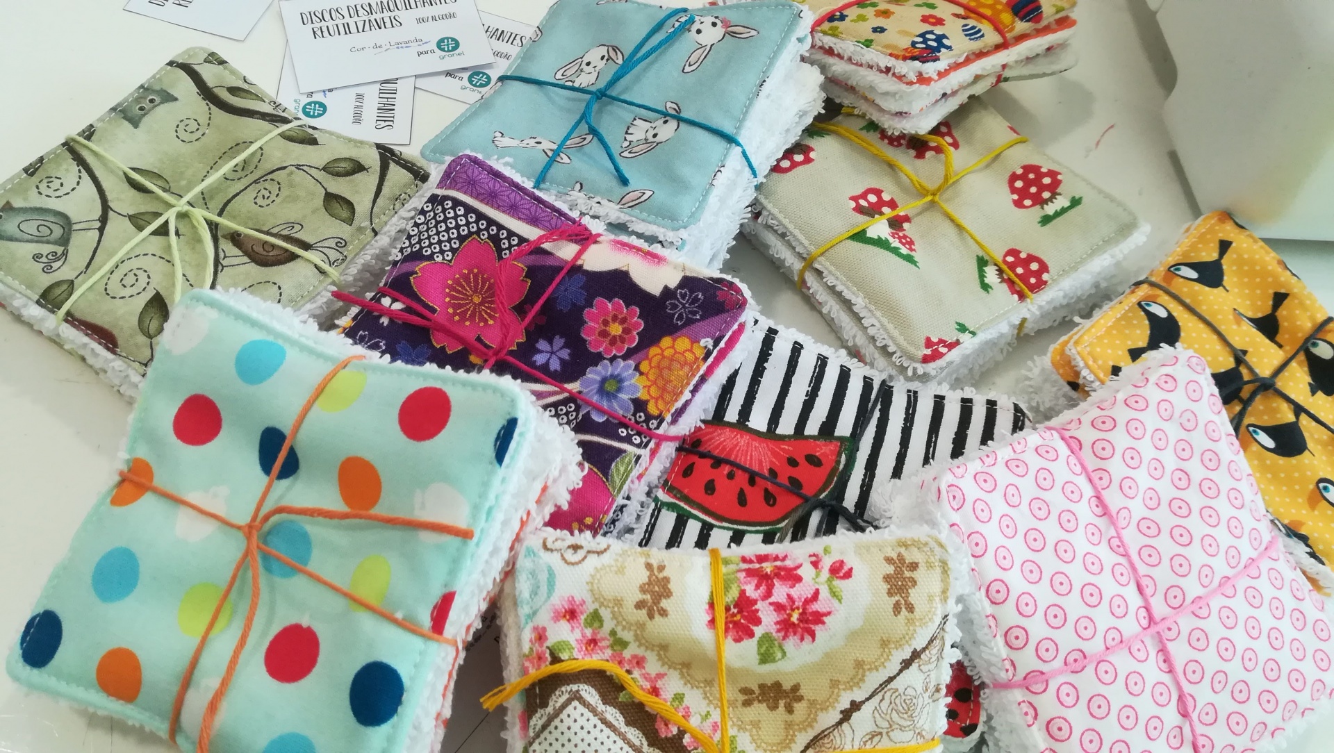 Conjuntos de tecidos dobrados com vários padrões coloridos, ligados com cordelinhos.