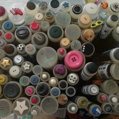 Bobinas de linha coloridas vistas de cima organizadas em filas sobre superfície branca