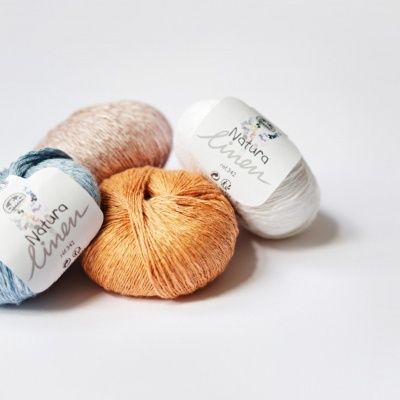 Quatro novelos de fio Natura Linen da Pingouin em várias cores sobre fundo branco