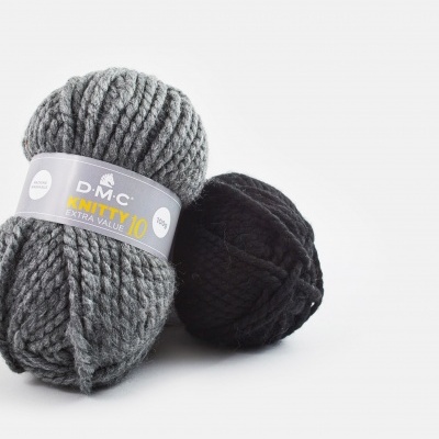 Dois novelos de lã, um cinza com etiqueta e outro preto, sobre fundo branco