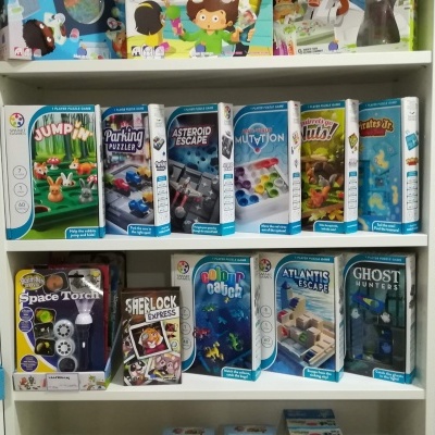 Caixas de jogos de tabuleiro e de escape em prateleiras brancas