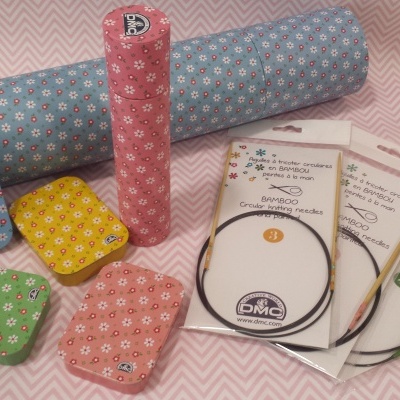 Tecidos coloridos com padrão floral e agulhas circulares para tricô