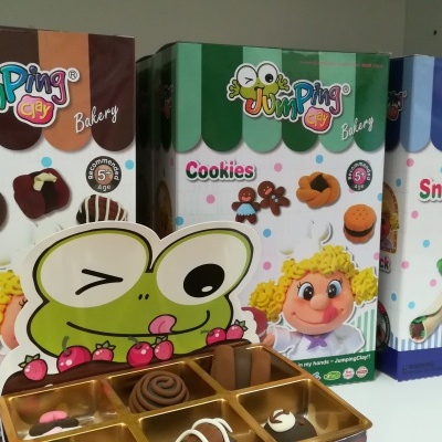 Embalagens coloridas de produtos Jumping com desenhos de uma rã e uma personagem loira