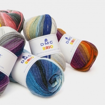 Quatro novelos de lã multicolorida DMC BRIO sobre fundo branco