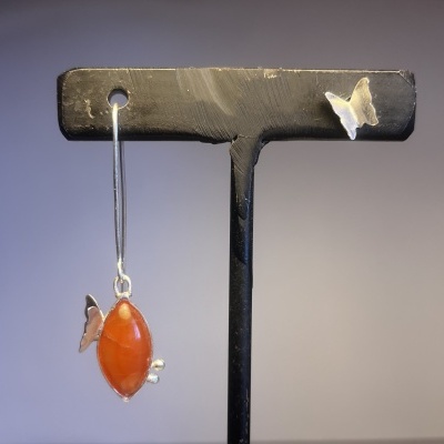 Brinco pendente com pedra oval laranja e borboleta metálica em suporte preto