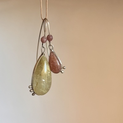Par de brincos com pedras em forma de gota em amarelo e vermelho montados em metal prateado