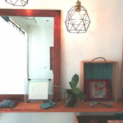 Espelho de madeira com candeeiro geométrico metálico e prateleira de madeira com pequenos objetos