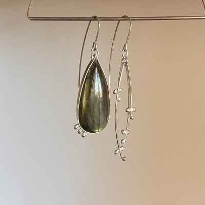 Brincos assimétricos metálicos com pedra oval verde e design de ramo prateado