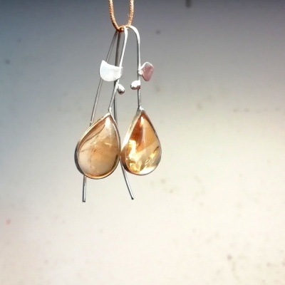 Brincos pendentes com pedras em gota amarelas e estrutura metálica prateada