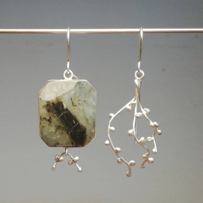 Par de brincos assimétricos com pedra e design de raminho em metal prateado