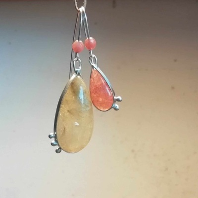 Brincos pendentes com pedras em tons amarelo e salmão com detalhes metálicos